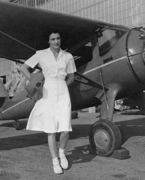 Aline in White Dress With Airplane, Date & Location Unknown (Source: Roberts)